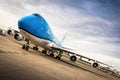 Blue airplane front view. Cargo Boeing 747 on the ground. Diagonal view of the wings and four engines.