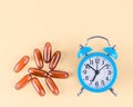 Blue alarm clock and capsules. Royalty Free Stock Photo