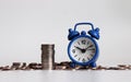 Blue alarm clock and coins. Concepts about budgets and schedules. Royalty Free Stock Photo