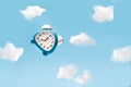 Blue alarm clock flies in the clouds Royalty Free Stock Photo