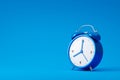 Blue alarm clock isolated on blue background with retro style. Classic analog clock and blank space. 3D rendering