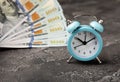 Blue alarm clock on money banknotes Dollars, business planning and finance concept Royalty Free Stock Photo