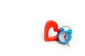 Blue alarm clock and red heart on a white background. The concept of time and planning. Minimalism. Life expectancy. Intimate serv Royalty Free Stock Photo