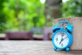 Blue alarm clock on wooden with green blurred back Royalty Free Stock Photo