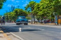 Blue american classic car drive on the road trough Varadero Cuba with carriage on the street side