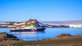 Blue antarctic cruise ship in the lagoon and Gentoo penguins col