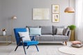 Blue armchair near grey settee in modern living room interior wi Royalty Free Stock Photo