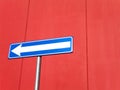 Blue arrow sign on red