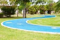 Blue asphalt path via green grass