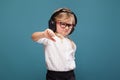 Pretty, cute little girl in white shirt, glasses, black trousers and headphones Royalty Free Stock Photo