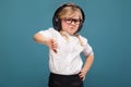 Pretty, cute little girl in white shirt, glasses, black trousers and headphones Royalty Free Stock Photo