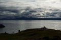 Blue autumn fjord, man on park bench and boat Royalty Free Stock Photo