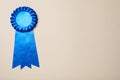Blue award ribbon on beige background, top view. Space for text Royalty Free Stock Photo