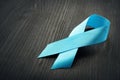 Blue awareness ribbon on a black desk. Prostate Cancer