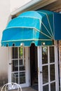 Blue awning over door and brick wall background.