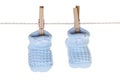 Blue baby booties hanging from washing line with wooden pegs Royalty Free Stock Photo