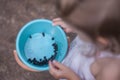 Blue baby bucket with blueberries in the hands of a little girl. Picking berries in the forest. Royalty Free Stock Photo