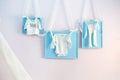 Blue baby clothes on the clothesline ribbons on the wall Royalty Free Stock Photo