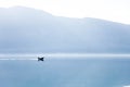 Blue background. Boat with fisherman on sea. Fishing in foggy morning lake. Amazing nature Royalty Free Stock Photo