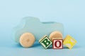 Blue background with colored cubes with letters Boy and wooden toy car Royalty Free Stock Photo