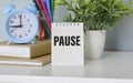 On a blue background - colored pencils, a flower and an alarm clock with a notepad with the inscription PAUSE Royalty Free Stock Photo