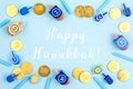 Blue background with dreidels, menora candles and chocolate coins with Happy Hanukkah wording Royalty Free Stock Photo