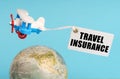 On a blue background, a globe and an airplane with a sign - Travel Insurance Royalty Free Stock Photo