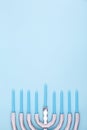 Blue background with menora and candles. Hanukkah and judaic holiday concept.