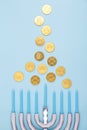 Blue background with menora and chocolate coins. Hanukkah and judaic holiday concept.