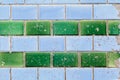 Four horizontal rows of old rectangular ceramic tiles of sky-blue and green color, covered with many small cracks
