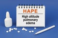 On a blue background, a pen, tablets and a notepad with the inscription - HAPE High altitude pulmonary edema