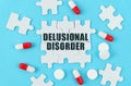 On a blue background, pills, capsules and puzzles with the inscription - Delusional disorder