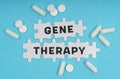 On a blue background pills and puzzles with the inscription - GENE THERAPY Royalty Free Stock Photo