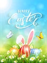 Blue background with rabbit and three Easter eggs in grass Royalty Free Stock Photo