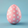 A blue background serves as the setting for a pastel pink Easter egg adorned with polka dots Royalty Free Stock Photo