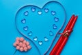 On a blue background  there is a heart made of transparent pebbles in the shape of hearts  next to a ribbon for decoration  next Royalty Free Stock Photo