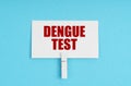 On a blue background, there are pills and a business card with the inscription - dengue test