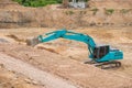 Blue backhoe excavating soil and sand