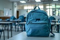 Blue Backpack on Classroom Desk in an Empty Schoolroom, Back to School Concept Royalty Free Stock Photo