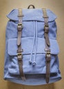 Blue backpack with leather elements on wood board