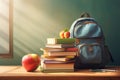 A blue backpack in school classroom on the desk. School stationery, red apple, books, notebooks. Preparation for school Royalty Free Stock Photo