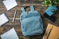 Blue backpack sits on a wooden table with a few notebooks and pens Royalty Free Stock Photo