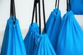 Blue bags hanging on black laces