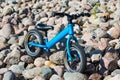 The blue balance bike on a rocky surface