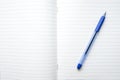 A blue ball pen lying on a blank lined school notebook sheet , paper with copy space Royalty Free Stock Photo