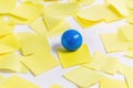 A blue ball perched atop a stack of yellow post-it notes, ideal for use in illustrations or designs about creativity Royalty Free Stock Photo