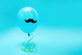 A blue balloon with a felt mustache floating in the air with on a blue background. Copy space. The concept of Father