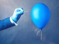 Blue balloon. Man hold needle directed to air balloon. Royalty Free Stock Photo