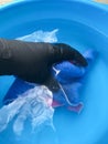 Hand wash napkins in a blue basin. female hand in black glove washes clothes Royalty Free Stock Photo