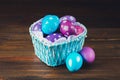 Blue Basket in the form of heart with Easter eggs. Brown wooden Royalty Free Stock Photo
